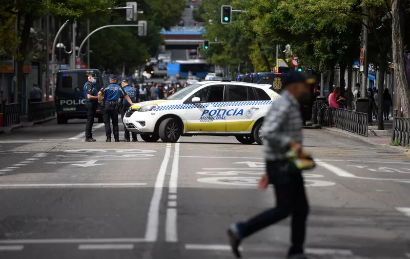 Policemen  block a street at the Vallecas neighborhood in Madrid, on September 20, 2020, during a demonstration against the new restrictive measures announced by regional authorities. - The Madrid region, the epicentre of an explosion of virus infections in Spain, would place a partial lockdown on hundreds of thousands of people. Residents of the affected areas -- 858,000 or 13 percent of the 6.6 million population -- will only be allowed to leave the zone to go to work, seek medical care or take their children to school. (Photo by OSCAR DEL POZO / AFP)