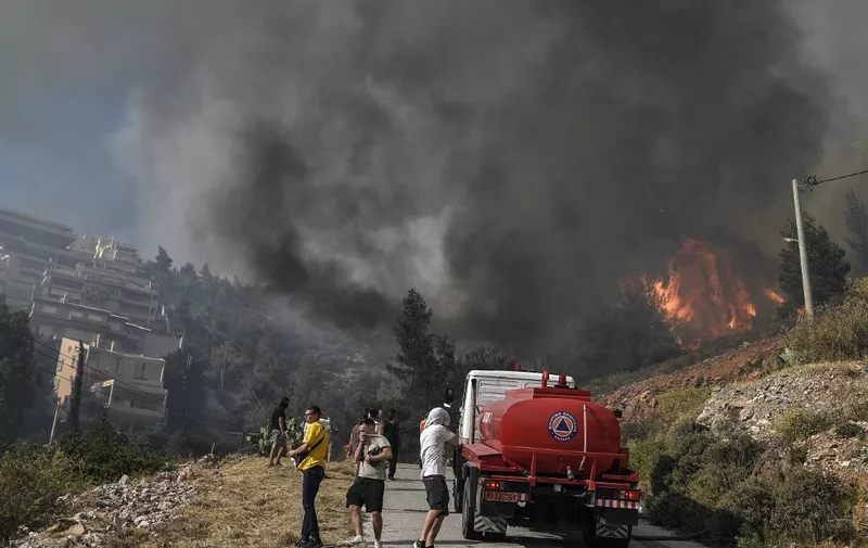 Firemen try to keep the fire away from residental area in Panorama Voulas, south of Athens on June 4, 2022. - A wildfire whipped by gale-force winds blazed through vegetation in a southern suburb of Athens, the fire brigade said, forcing residents to evacuate. (Photo by Louisa GOULIAMAKI / AFP)
