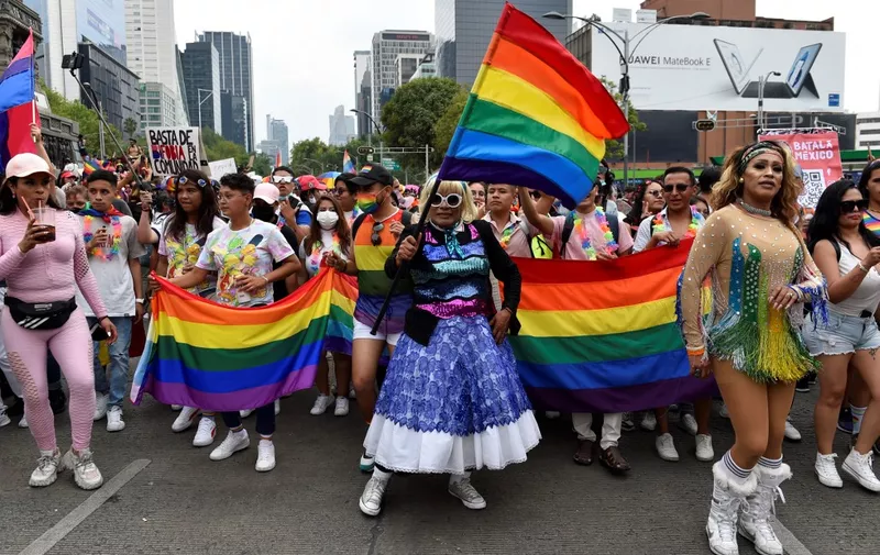 Attendees holding Rainbow flags march during the Pride Parade in Mexico City on June 25, 2022. (Photo by Alfredo ESTRELLA / AFP)