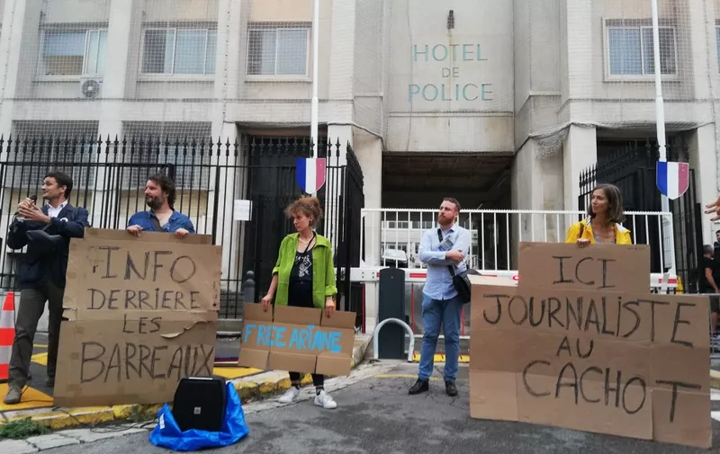 Protesters hold placards reading "information behind bars" (L) and "here, journalist in jail" as they demonstrate in front of the police headquarters in Marseille, southern France, in support of journalist Ariane Lavrilleux, who has been taken into police custody as part of an investigation into the compromise of national defense secrets, on September 20, 2023. (Photo by Isabelle WESSELINGH / AFP)