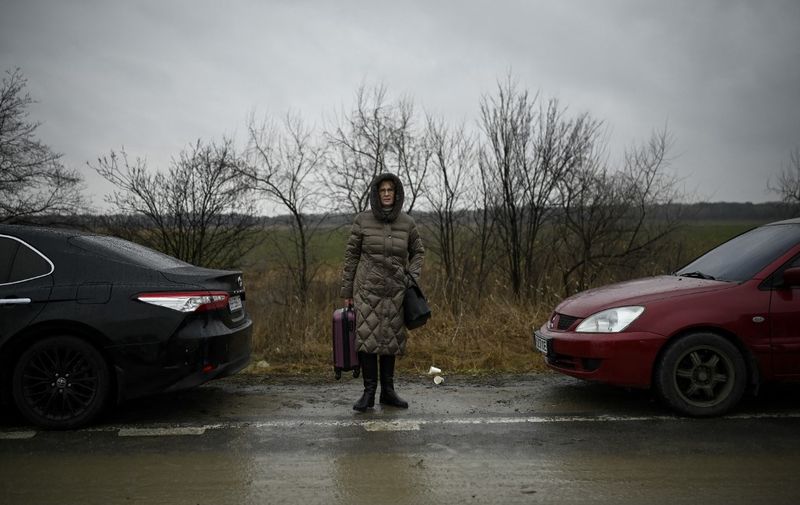 A refugee woman from Ukraine waits for transportation at the Moldova-Ukrainian border's checkpoint near the town of Palanca on March 1, 2022. (Photo by Nikolay DOYCHINOV / AFP)