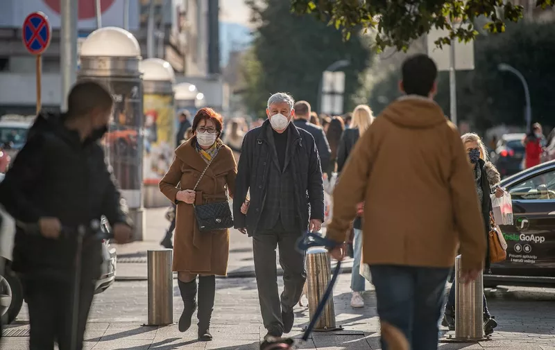 PODGORICA, MONTENEGRO - FEBRUARY 01: People, wearing medical masks, walk through the street amid the novel type of coronavirus (COVID-19) pandemic during their daily lives in Podgorica, Montenegro on February 01, 2021. Ordered COVID-19 vaccines have not yet arrived in the country. Adel Omeragic / Anadolu Agency (Photo by Adel Omeragic / ANADOLU AGENCY / Anadolu Agency via AFP)