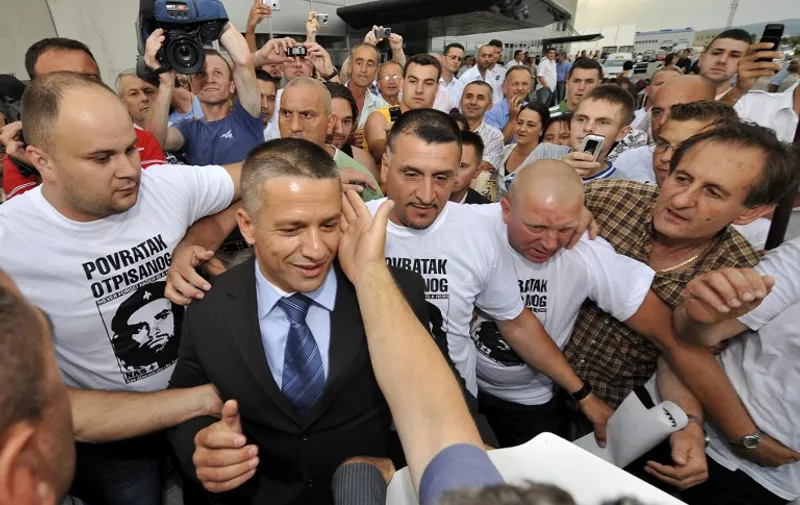 Former commander of Bosnian Muslim forces in Srebrenica Naser Oric (2ndL), 41, is greeted by supporters as he arrives at Sarajevo International Airport on July 4, 2008, one day after he was cleared of war crimes against Serbs by a The Hague's UN tribunal. Oric was charged with warcrimes of failing to prevent his subordinates in maltreating and killing Bosnian Serb prisoners of war held in Srebrenica in 1992 and 1993.   AFP PHOTO/ ELVIS BARUKCIC