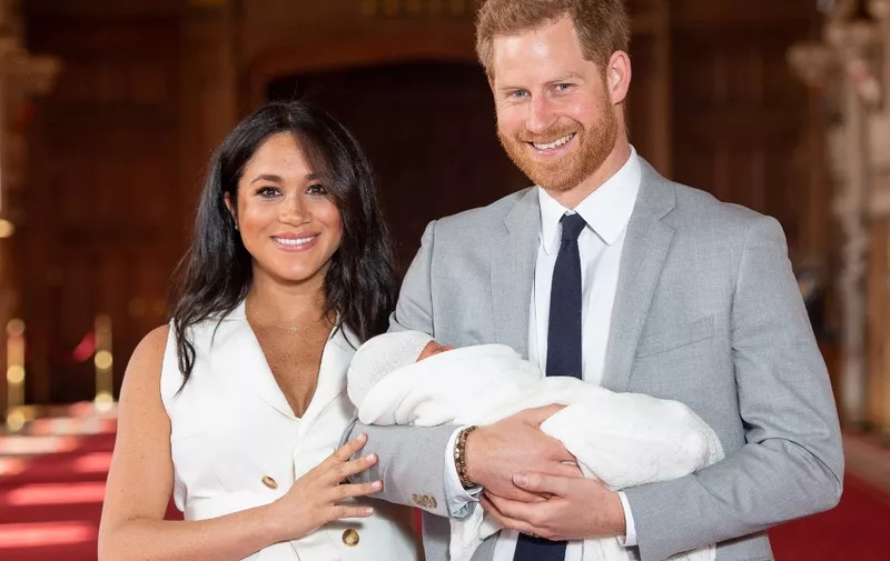 (FILES) In this file photo taken on May 08, 2019 Britain's Prince Harry, Duke of Sussex (R), and his wife Meghan, Duchess of Sussex, pose for a photo with their newborn baby son, Archie Harrison Mountbatten-Windsor, in St George's Hall at Windsor Castle in Windsor, west of London. - Britain's Prince Harry and his wife Meghan will step back as senior members of the royal family and spend more time in North America, the couple said in a historic statement Wednesday. (Photo by Dominic Lipinski / POOL / AFP)