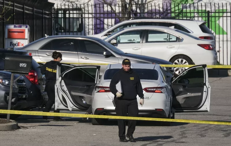 Crime scene investigators walk through the parking lot of the mass shooting site at a FedEx facility in Indianapolis, Indiana, on April 16, 2021. - A gunman has killed at least eight people at the facility before turning the gun on himself in the latest in a string of mass shootings in the country, authorities said. The incident came a week after President Joe Biden branded US gun violence an "epidemic" and an "international embarrassment" as he waded into the tense debate over gun control, a powerful political issue in the US. (Photo by Jeff Dean / AFP)