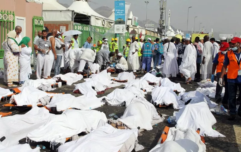 GRAPHIC CONTENT
Saudi emergency personnel stand near bodies of Hajj pilgrims at the site where at least 717 were killed and hundreds wounded in a stampede in Mina, near the holy city of Mecca, at the annual hajj in Saudi Arabia on September 24, 2015. The stampede, the second deadly accident to strike the pilgrims this year, broke out during the symbolic stoning of the devil ritual, the Saudi civil defence service said. AFP PHOTO / STR