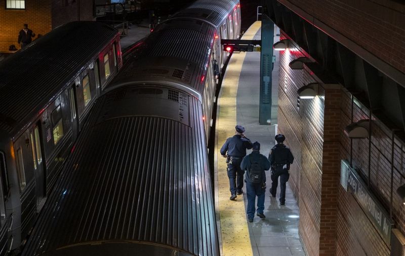 Metopolitan Transportation Authority Police(MTA) officers walk the subway platform to clear the subway cars of passengers at the last stop at the Coney Island station in Brooklyn, New York on May 6, 2020. - The New York City subway system is being suspended between 1 AM and 5 AM EDT starting tonight so that trains may be cleaned to stop the spread of the coronavirus. (Photo by COREY SIPKIN / AFP) / The erroneous mention[s] appearing in the metadata of this photo by COREY SIPKIN has been modified in AFP systems in the following manner: [Metopolitan Transportation Authority Police(MTA) officers ] instead of [NYPD officers]. Please immediately remove the erroneous mention[s] from all your online services and delete it (them) from your servers. If you have been authorized by AFP to distribute it (them) to third parties, please ensure that the same actions are carried out by them. Failure to promptly comply with these instructions will entail liability on your part for any continued or post notification usage. Therefore we thank you very much for all your attention and prompt action. We are sorry for the inconvenience this notification may cause and remain at your disposal for any further information you may require.