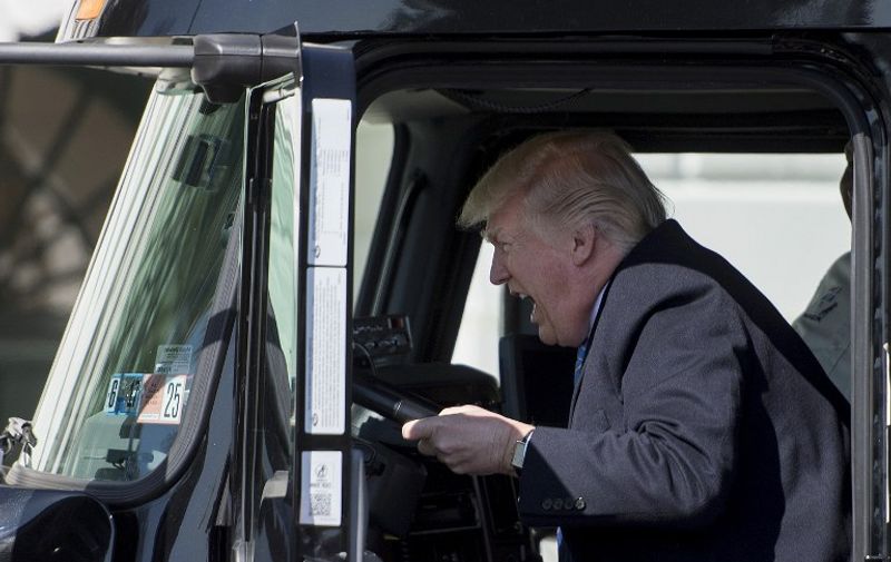 US President Donald Trump sits in the drivers seat of a semi-truck as he welcomes truckers and CEOs to the White House in Washington, DC, March 23, 2017, to discuss healthcare. / AFP PHOTO / JIM WATSON
