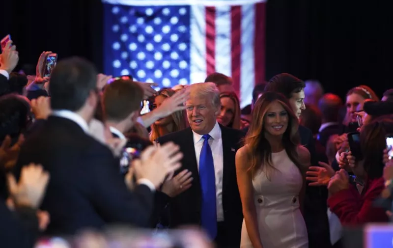 US Republican presidential candidate Donald Trump (C) greets his supporters as he arrives to speak in New York on May 3, 2016, following the primary in Indiana. 
Donald Trump crushed his Republican rivals in Indiana's primary Tuesday, bringing him to the brink of outright victory in the presidential nomination race and dashing the hopes of a movement bent on stopping him. / AFP PHOTO / Jewel SAMAD