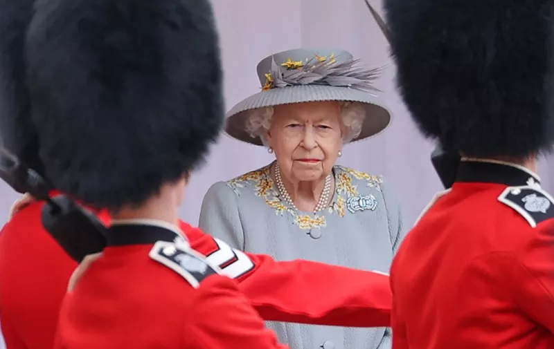 (FILES) In this file photo taken on June 12, 2021 Britain's Queen Elizabeth II watches a military ceremony to mark her official birthday at Windsor Castle, in Windsor. - Gun salutes will ring out Thursday to mark Queen Elizabeth II's 96th birthday, although the monarch herself was expected to mark the occasion with little fanfare. (Photo by Chris Jackson / POOL / AFP)