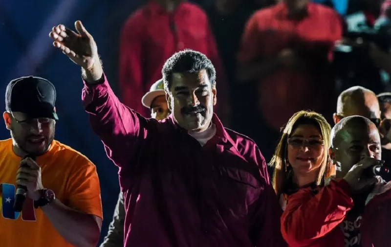 Venezuelan President Nicolas Maduro waves to his supporters after the National Electoral Council (CNE) announced the results of the voting on election day in Venezuela, on May 20, 2018.
President Nicolas Maduro was declared winner of Venezuela's election Sunday in a poll rejected as invalid by his rivals, who called for fresh elections to be held later this year. With more than 90 percent of the votes counted,  Maduro had 67.7 percent of the vote, with his main rival Henri Falcon taking 21.2 percent, the National Election Council chief Tibisay Lucena announced. / AFP PHOTO / Juan BARRETO