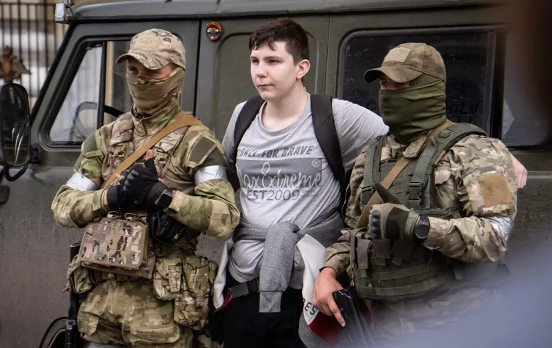 A man poses for a photo with members of Wagner group in a street in the city of Rostov-on-Don on June 24, 2023. President Vladimir Putin on June 24, 2023 said an armed mutiny by Wagner mercenaries was a "stab in the back" and that the group's chief Yevgeny Prigozhin had betrayed Russia, as he vowed to punish the dissidents. Prigozhin said his fighters control key military sites in the southern city of Rostov-on-Don. (Photo by Roman ROMOKHOV / AFP)