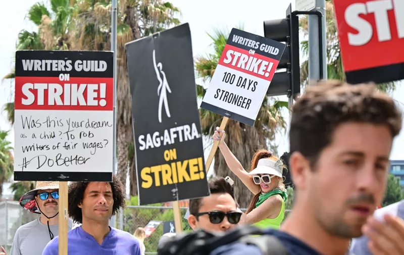 Members of the Writers Guild of America (WGA) and the Screen Actors Guild walk the picket line outside of Netflix in Hollywood, California, on August 9, 2023. Film and TV production ground to a halt 100 days ago when writers downed their pens, only to be joined on the picket lines in mid-July by actors. (Photo by Frederic J. BROWN / AFP)