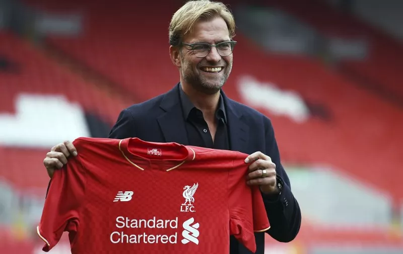 Liverpool's new German manager Jurgen Klopp poses with a team jersey after a press conference to announce his new appointment at Anfield in Liverpool, northwest England, on October 9, 2015. Klopp described his job as "the biggest challenge" in world football on October 9 following his appointment as the successor to Brendan Rodgers. Former Borussia Dortmund head coach Klopp, 48, was appointed on October 8 on a three-year contract following the dismissal of Rodgers, who was sacked October 4 after three and a half years at the club.  AFP PHOTO / PAUL ELLIS  

RESTRICTED TO EDITORIAL USE. No use with unauthorized audio, video, data, fixture lists, club/league logos or 'live' services. Online in-match use limited to 75 images, no video emulation. No use in betting, games or single club/league/player publications.