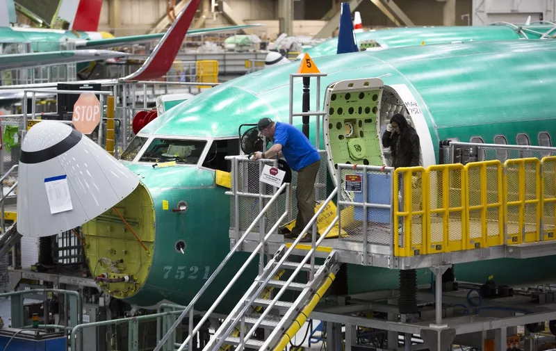 (FILES) In this file photo taken on March 27, 2019 Employees work on Boeing 737 MAX airplanes at the Boeing Renton Factory in Renton, Washington. - Boeing could on December 16, 2019 announce whether to further cut or suspend production of its grounded 737 MAX plane, The Wall Street Journal reported on December 15, 2019. (Photo by Jason Redmond / AFP)