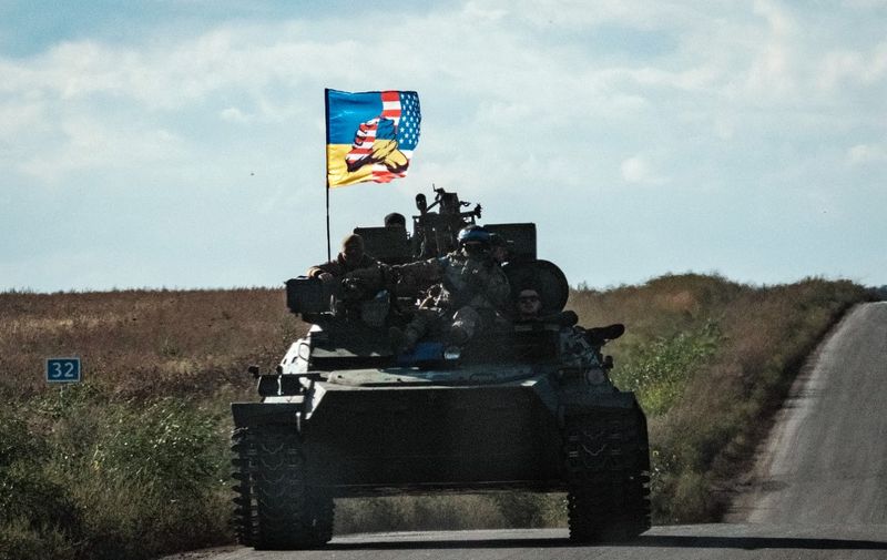 A Ukrainian tank rides with a flag picturing Ukraine and US flags shaking hands in Novostepanivka, Kharkiv region, on September 19, 2022, amid the Russian invasion of Ukraine. (Photo by Yasuyoshi CHIBA / AFP)