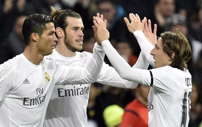 Real Madrid's Welsh forward Gareth Bale (C) is congratulated by Real Madrid's Portuguese forward Cristiano Ronaldo (L) and Real Madrid's Croatian midfielder Luka Modric after scoring during the Spanish league football match Real Madrid CF vs RC Deportivo La Coruna at the Santiago Bernabeu stadium in Madrid on January 9, 2016.  AFP PHOTO / GERARD JULIEN / AFP PHOTO / GERARD JULIEN