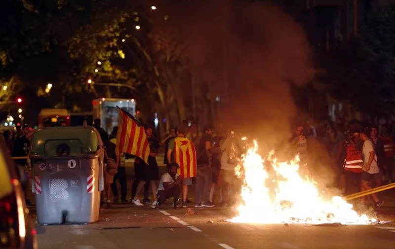 Protesters burn garbage from trash containers after a demonstration held in Barcelona on October 1, 2018 to commemorate the first anniversary of a banned referendum on secession, erupted into riot.
A year after a banned referendum on secession from Spain, tens of thousands of Catalan militants piled pressure on the region's separatist government today during an anniversary marked by road and railway line blockades. / AFP PHOTO / Pau Barrena