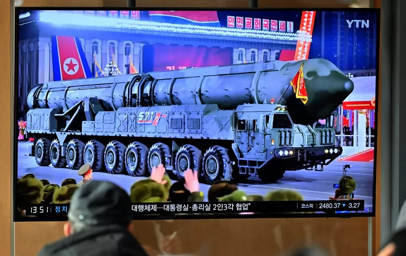 A man watches a television screen showing a news broadcast with an image of a North Korean military parade held in Pyongyang to mark the 75th founding anniversary of its armed forces, at a railway station in Seoul on February 9, 2023. - North Korea's Kim Jong Un oversaw a major military parade showcasing a record number of nuclear and intercontinental ballistic missiles, state media reported on February 9, including what analysts said was possibly a new solid-fueled ICBM. (Photo by Jung Yeon-je / AFP)