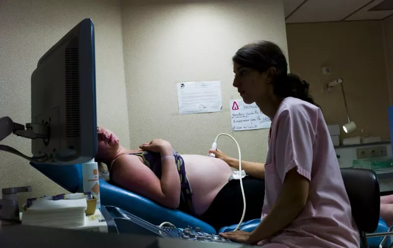 A doctor makes an ultrasound to a patient at the maternity of the Argenteuil hospital, in a Paris suburb, on July 22, 2013.  AFP PHOTO / FRED DUFOUR / AFP / FRED DUFOUR