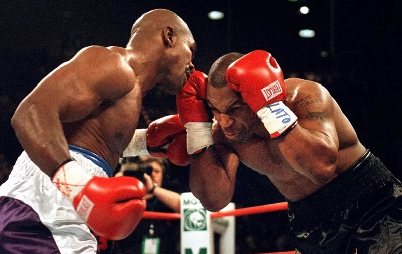 Mike Tyson (R) protects himself from Evander Holyfield during the first round 28 June 1997 of their WBA heavyweight championship fight at the MGM Grand Garden Arena in Las Vegas, NV. Holyfield won on a disqualifiation at the end of the third round.  AFP PHOTO/JEFF HAYNES (Photo by JEFF HAYNES / AFP)