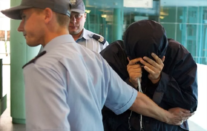 Suspected Israeli spy Uri Brodsky (R) is accompanied by police after being captured at Warsaw airport on August 5, 2010. Brodsky will be brought to the court of appeals in Warsaw. AFP PHOTO/MARCIN LOBACZEWSKI / AFP PHOTO / Marcin Lobaczewski