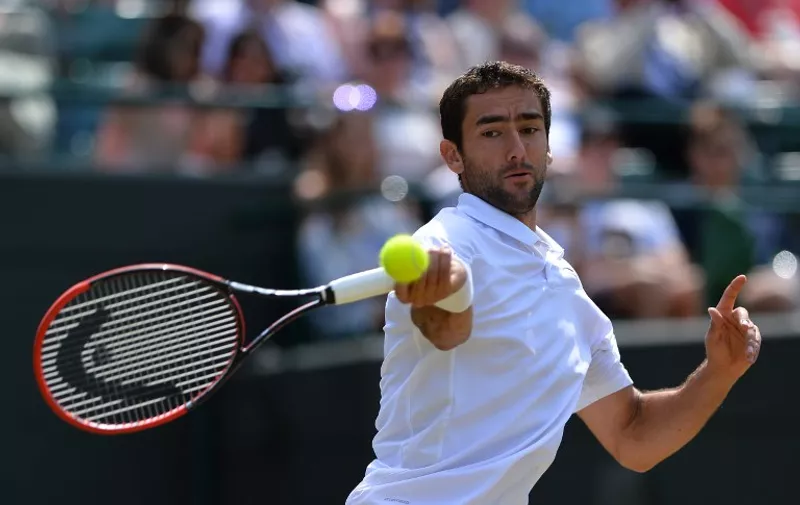 Croatia's Marin Cilic returns against US player John Isner during their men's singles third round match on day six of the 2015 Wimbledon Championships at The All England Tennis Club in Wimbledon, southwest London, on July 4, 2015.   RESTRICTED TO EDITORIAL USE  --  AFP PHOTO / GLYN KIRK