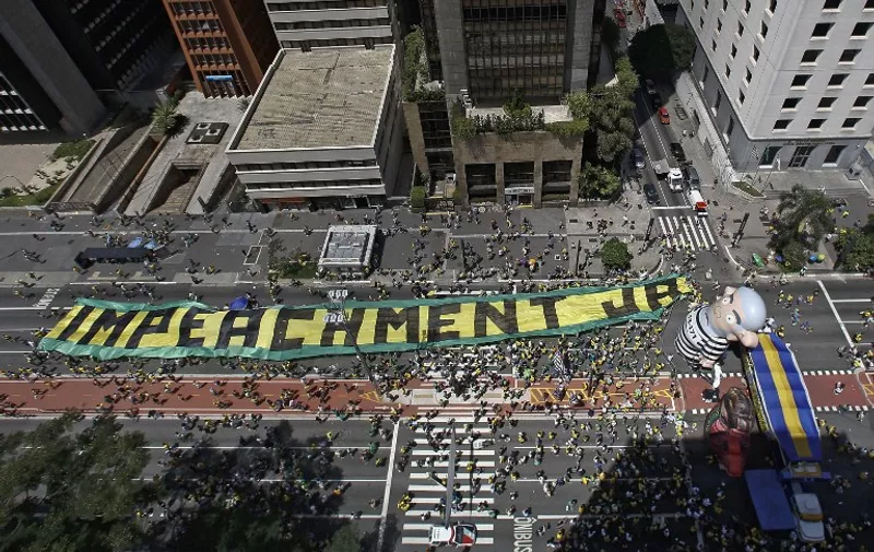 Demonstrators rally in support of Brazilian President Dilma Rousseff's impeachment at Paulista Avenue, in Sao Paulo, Brazil on December 13, 2015. Thousands of demonstrators clad in the yellow and green national flag's colors protested Sunday in several cities of Brazil to demand Rousseff's removal from office. Brazil's Supreme Court on Tuesday suspended action by a special congressional commission weighing impeachment proceedings against embattled President Rousseff. The move freezes the impeachment process until December 16 when the court convenes for a full session. AFP PHOTO / Miguel SCHINCARIOL / AFP / Miguel Schincariol