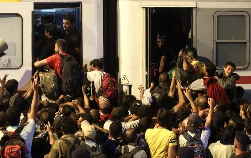 18.08.2015., Tovarnik - Oko 21 sat stigao je vlak iz Zagreba. Izbjeglice su ga docekale pljeskom, a zatim je poceo stampedo. Interventna policija ih usmjerava, ali ne intervenira. U vlak stane oko 1100 ljudi i to nece biti dovoljno za sve koji se tamo nalaze. Izbjeglice se guraju, svadjaju i vicu, neki ulaze kroz prozore. Zene s malom djecom su se maknule sa strane. Vlak ce ih prevesti do u Belog Manastira. 
Photo: Zeljko Lukunic/PIXSELL