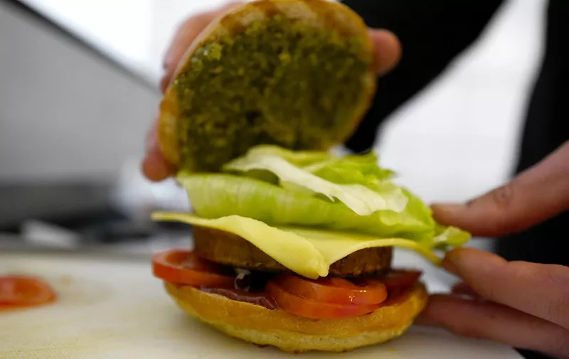 Chef Johannes Thenerl prepares a vegan "burger" using a patty made of wild garlic (Baerlauch) at the vegan restaurant "L'Herbivore" in Berlin on April 29, 2016. (Photo by John MACDOUGALL / AFP) / TO GO WITH AFP STORY BY Yannick PASQUET