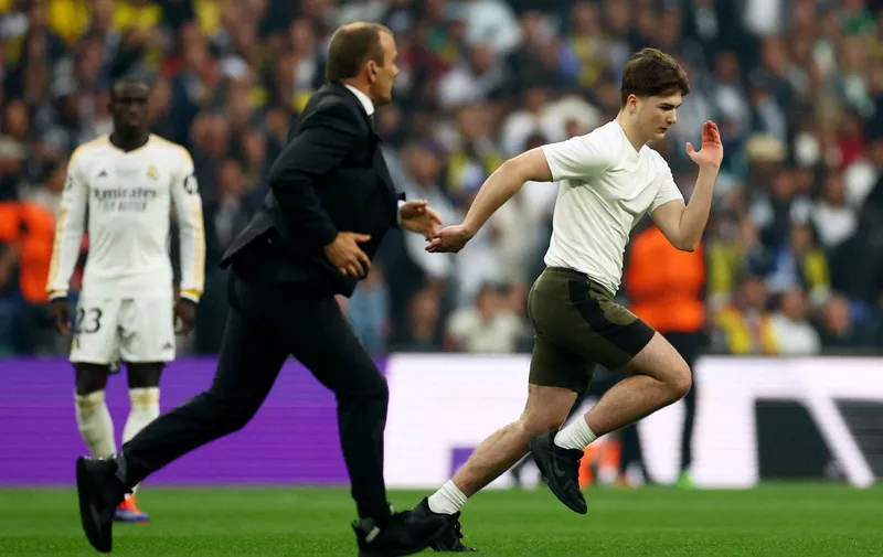 Soccer Football - Champions League - Final - Borussia Dortmund v Real Madrid - Wembley Stadium, London, Britain - June 1, 2024 A pitch invader is chased by a member of security at the beginning of the match REUTERS/Carl Recine
