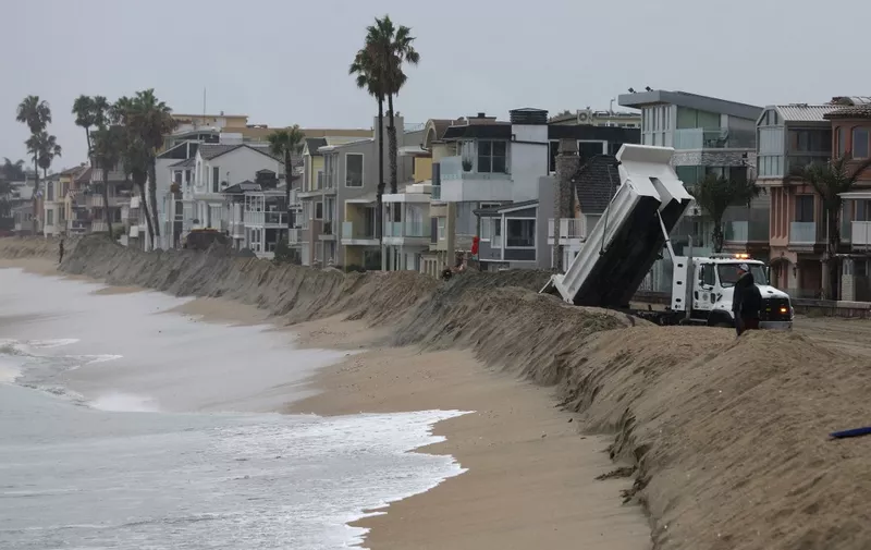 LONG BEACH, CALIFORNIA - AUGUST 20: Workers build a sand berm outside of beachfront homes on August 20, 2023 in Long Beach, California. Southern California is under a first-ever tropical storm warning as Hilary approaches with parts of California, Arizona, and Nevada preparing for flooding and heavy rains. All California state beaches have been closed in San Diego and Orange counties in preparation for the impacts of the storm which was downgraded from hurricane status.   Justin Sullivan/Getty Images/AFP (Photo by JUSTIN SULLIVAN / GETTY IMAGES NORTH AMERICA / Getty Images via AFP)