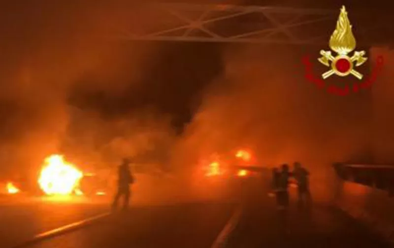 This photo taken and handout on January 29, 2020 by the Italian Department of firefighters, the Vigili del Fuoco, shows rescuers intervening after criminals attempted to ambush an armoured truck on a stretch of highway between Milan and Lodi, in San Zenone al Lambro. - Several burning vehicles on a highway in northern Italy were set up to stop an armored truck carrying cash, but the truck's driver managed to drive through the wall of fire and escape. The attack occurred shortly before midnight late on January 28, 2020, as criminals set fire to about ten vehicles, all probably stolen, in both directions of travel on the motorway. (Photo by Handout / various sources / AFP) / RESTRICTED TO EDITORIAL USE - MANDATORY CREDIT "AFP PHOTO / VIGILI DEL FUOCO / ITALIAN DEPARTMENT OF FIREFIGHTERS" - NO MARKETING - NO ADVERTISING CAMPAIGNS - DISTRIBUTED AS A SERVICE TO CLIENTS
