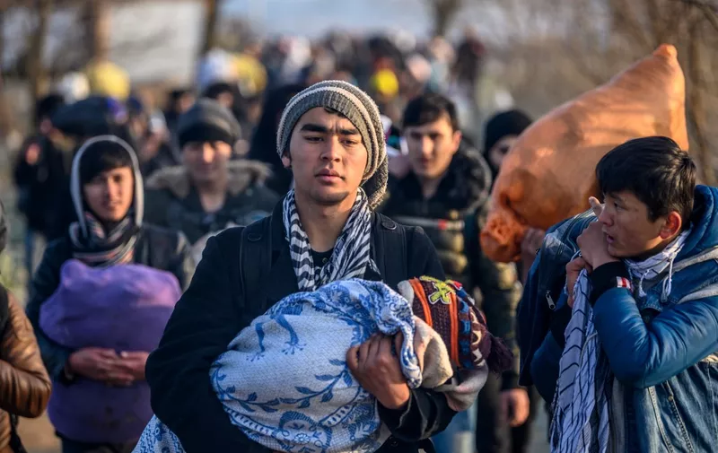 Migrants walk towards the Greek border in Pazarkule, in the Edirne district, on March 1, 2020. - Thousands of migrants stuck on the Turkey-Greece border clashed with Greek police on February 29, 2020, according to an AFP photographer at the scene. Greek police fired tear gas at migrants who have amassed at a border crossing in the western Turkish province of Edirne, some of whom responded by hurling stones at the officers. The clashes come as Greece bolsters its border after Ankara said it would no longer prevent refugees from crossing into Europe following the death of 33 Turkish troops in northern Syria. (Photo by BULENT KILIC / AFP)