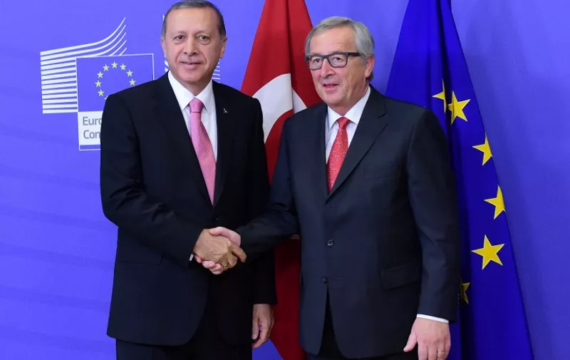Turkey's President Recep Tayyip Erdogan (L) is welcomed by European Commission President Jean-Claude Juncker at the European Commission in Brussels, on October 5, 2015. AFP PHOTO / EMMANUEL DUNAND