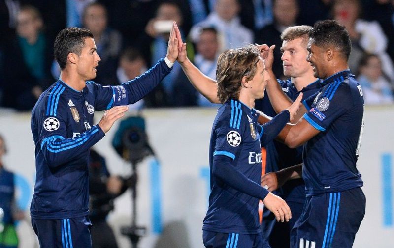 Real Madrid's Portuguese forward Cristiano Ronaldo (L) celebrates with his teammates after scoring during the UEFA Champions League first-leg Group A football match between Malmo FF and Real Madrid CF at the Swedbank Stadion, in Malmo, Sweden on September 30, 2015. 
AFP PHOTO / JONATHAN NACKSTRAND