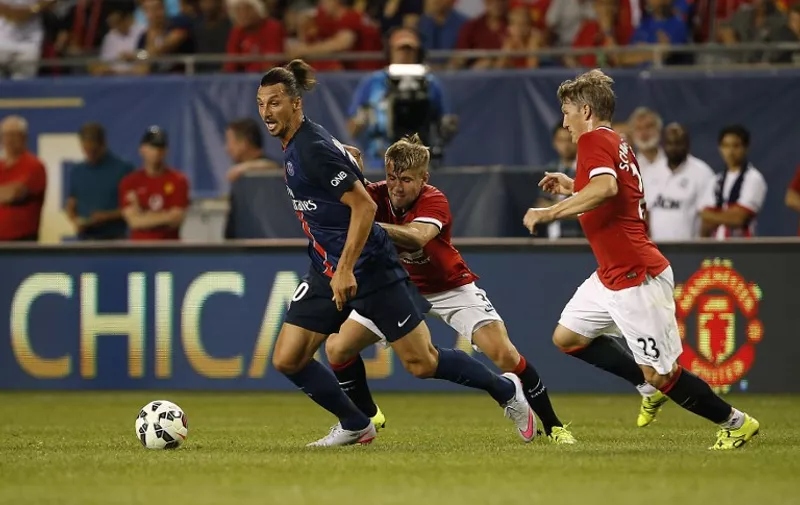 Paris Saint-Germain forward Zlatan Ibrahimovic, (L) controls the ball against Manchester United defender Luke Shaw (C) and defender Bastian Schweinsteiger during the second half of their International Champions Cup soccer game at Soldier Field in in Chicago, Illinois on July 29, 2015. AFP PHOTO/ JOSHUA LOTT