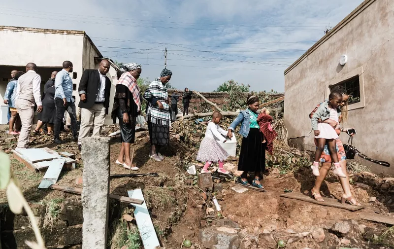 Relatives of the Jileka family leave for the The Church of the Holy Ghost after a private prayer done at their destroyed home during a funeral ceremony on April 24, 2022 in Hammarsdale, for five members of the Jileka, a single family who drowned when their home was engulfed in water following devastating floods and mudslides in Kwa-Zulu Natal province. - Over 400 people have been killed in floods and mudslides across South Africa's port city of Durban following heavy rains in the last week. (Photo by Rajesh JANTILAL / AFP)