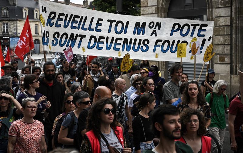 Protesters hold a banner reading "Wake up my mate, they've gone mad !" as they take part in a demonstration organized by feminist associations and trade unions against the far right, denouncing its "feminist facade" and the "real danger it represents" for women's rights, in Bordeaux, southwestern France, on June 23, 2024. (Photo by Philippe LOPEZ / AFP)