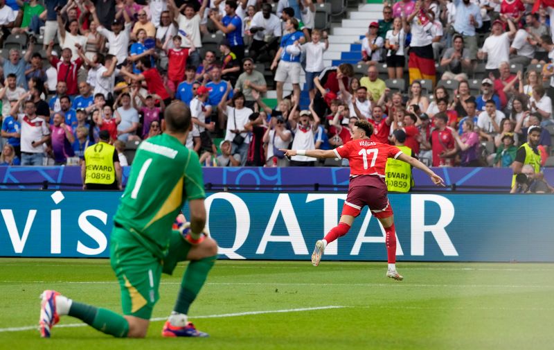 Italy's goalkeeper Gianluigi Donnarumma, in the foreground, watches Switzerland's Ruben Vargas celebrating after scoring his side's second goal during a round of sixteen match between Switzerland and Italy at the Euro 2024 soccer tournament in Berlin, Germany, Saturday, June 29, 2024. (AP Photo/Antonio Calanni)