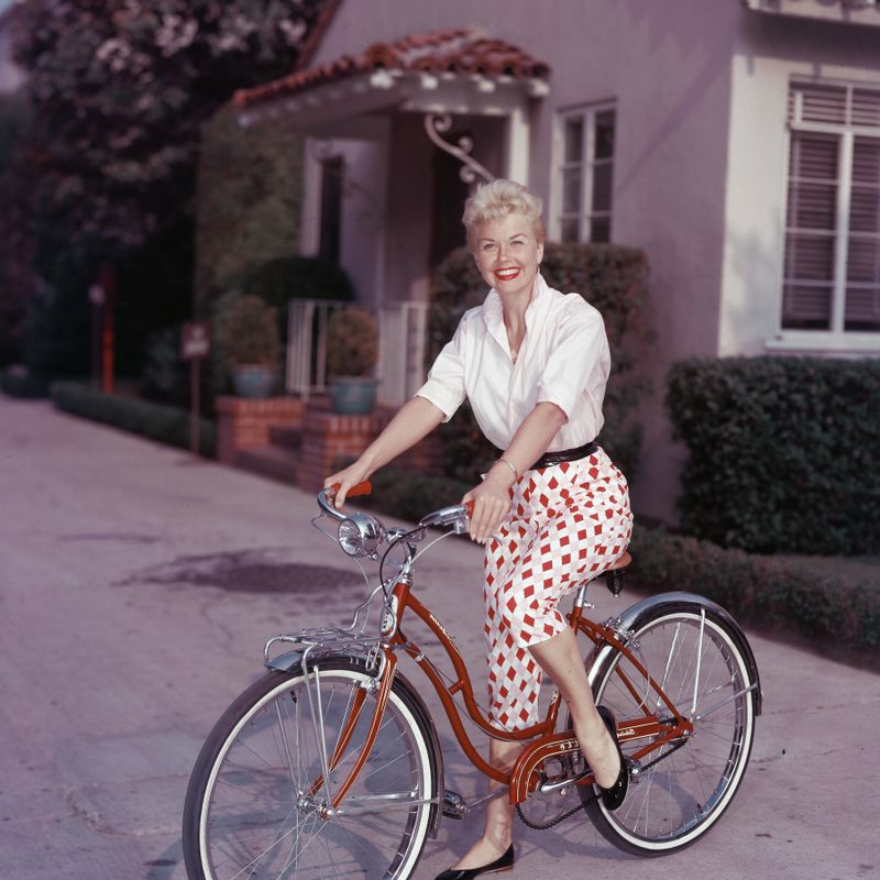 American actor Doris Day poses on a red Schwinn bicycle, late 1950s. (Photo by Hulton Archive/Getty Images)