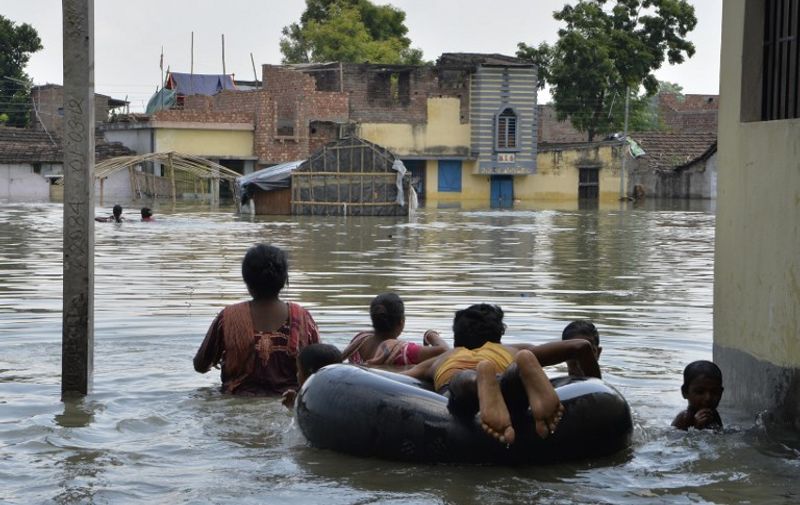 Indian residents wade through flood waters in Malda in the Indian state of West Bengal on August 24, 2017.
The death toll from floods sweeping South Asia has climbed above 1,000, officials said August 24, as rescue teams try to reach millions stranded by the region's worst monsoon disaster in recent years.
 / AFP PHOTO / DIPTENDU DUTTA