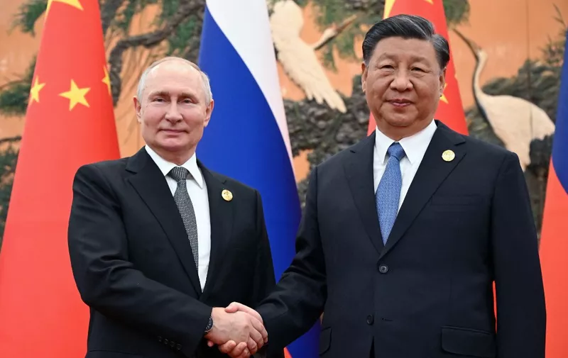 (FILES) This pool photograph distributed by Russian state owned agency Sputnik shows Russia's President Vladimir Putin and Chinese President Xi Jinping shaking hands during a meeting in Beijing on October 18, 2023. Russian President Vladimir Putin will visit China this week on the invitation of leader Xi Jinping, Beijing's foreign ministry said May 14, 2024. (Photo by Sergei GUNEYEV / POOL / AFP) / Editor's note: this image is distributed by Russian state owned agency Sputnik