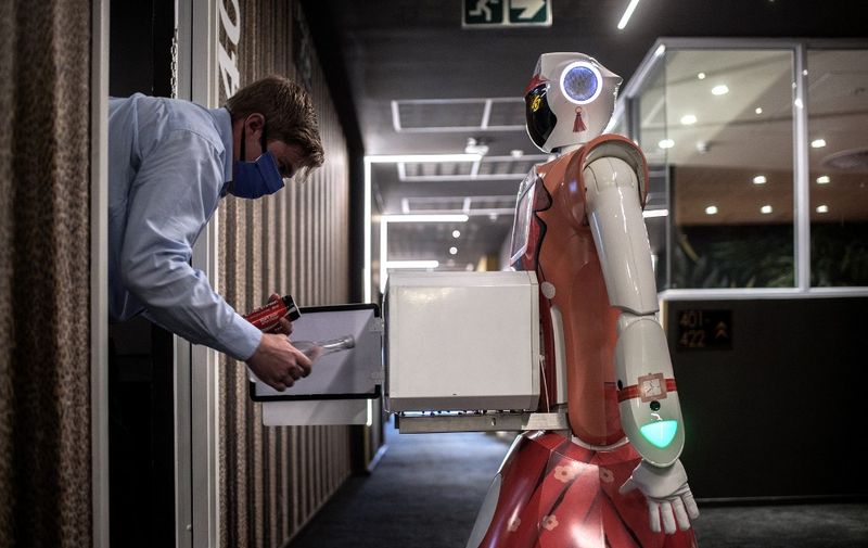 A technician by CTRL Robotics company performs a test of room service function of a robot in the Sky Hotel in Sandton, South Africa, on January 29, 2021. (Photo by Luca Sola / AFP)