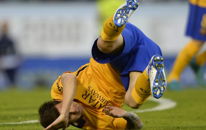 Barcelona's Argentinian forward Lionel Messi falls on the pitch  during the Spanish league football match Celta Vigo vs FC Barcelona at the Balaidos stadium in Vigo on September 23, 2015.  Celta won the match 4-1. AFP PHOTO / MIGUEL RIOPA