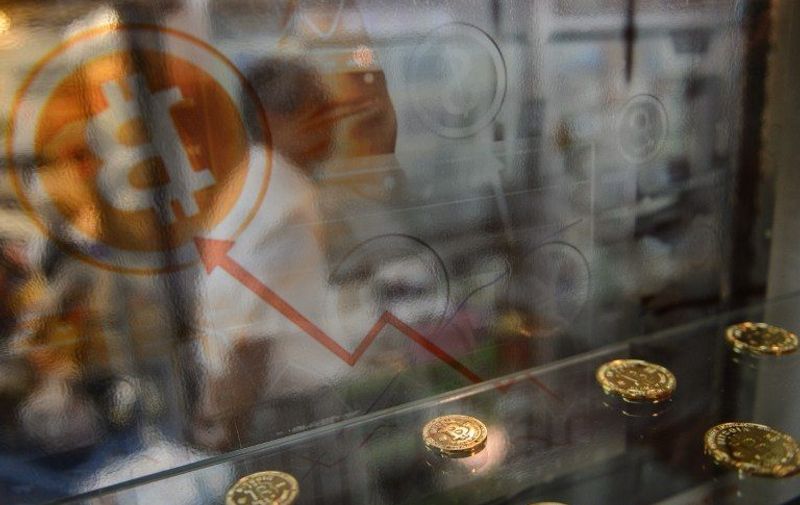 A man walks past a display cabinet containing models of Bitcoins in Hong Kong on August 3, 2016.
A major Hong Kong-based Bitcoin exchange has suspended trading after 65 million USD in the virtual unit was reportedly stolen by hackers -- sending the digital currency plunging more than 20 percent.
 / AFP PHOTO / ANTHONY WALLACE