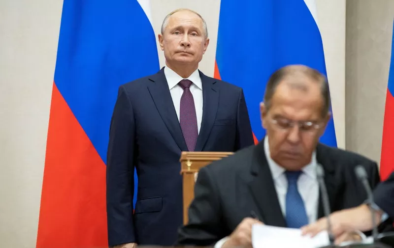 Russian Foreign Minister Sergei Lavrov (R) signs documents as Russian President Vladimir Putin attends a signing ceremony following his talks with Egyptian President in Sochi on October 17, 2018. (Photo by Pavel Golovkin / POOL / AFP)