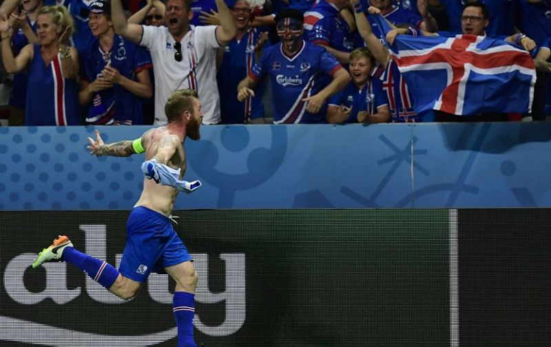 Iceland's midfielder Aron Gunnarsson celebrates the team's 2-1 win over England in the Euro 2016 round of 16 football match between England and Iceland at the Allianz Riviera stadium in Nice on June 27, 2016.   / AFP PHOTO / TOBIAS SCHWARZ