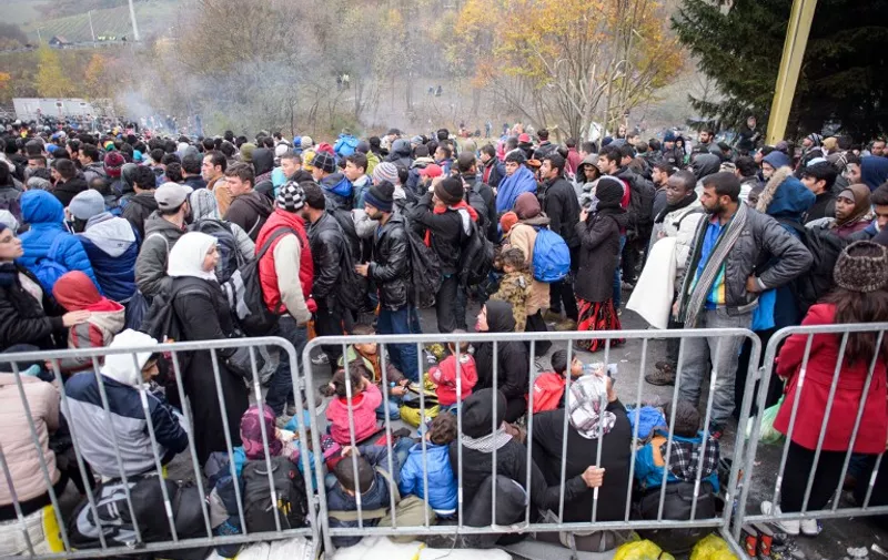 Migrants and refugees wait for buses in Sentilj, northeastern Slovenia, on October 28, 2015, to continue their journey and cross the Slovenia-Austria border. European Commission President Jean-Claude Juncker and Austrian Chancellor Werner Faymann warned on October 28 that fences were not welcome in the EU, after Vienna suggested it could build a barrier on its border with Slovenia to control an influx of migrants. Austria and Slovenia have become key transit points for tens of thousands of refugees and migrants seeking to reach northern Europe ahead of the winter. AFP PHOTO / RENE GOMOLJ