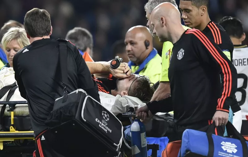 Manchester's defender Luke Shaw receives treatment after an injury during the UEFA Champions League Group B football match between PSV Eindhoven and Manchester United at the Philips stadium in Eindhoven, the Netherlands, on September 15, 2015. AFP PHOTO / JOHN THYS / AFP / JOHN THYS